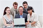 Smiling business team working with a laptop in an office