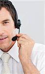 Close-up of an attractive businessman working in a call center with a headset on