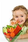 Little girl tasting and chomping a carrot - isolated