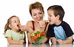 Woman feeding kids with fresh vegetables - the joy of eating healthy food