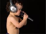 Sing baby with headphone and microphone,isolated on a black background.
