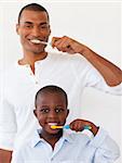 Father and his son brushing their teeth in the bathroom