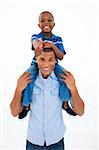Happy father giving son piggyback ride against white background