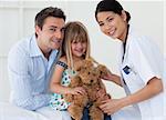 Doctor examining smiling child and father