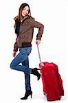 Young women ready for travel posing with her luggage indoor studio