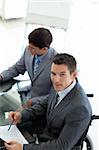 Attractive businessman in a wheelchair pointing a document