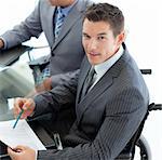 Close-up of a caucasian businessman in a wheelchair during a meeting with his colleagues