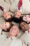 Multi-ethnic business team lying in a circle with heads together