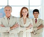 Business team with folded arms in a line smiling at the camera