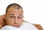 Man in bed trying to sleep with a pillow