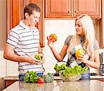 Young couple in the kitchen inspect peppers for their salad. Square shot.