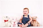 Portrait of cute laughing baby with plush toys