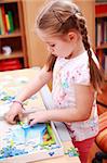 Cute child playing with puzzle