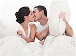 Couple kissing and playing on bed in bedroom, in passion over white background