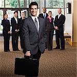 Young businessman with briefcase.  Vertically framed shot.