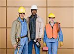 Construction workers standing and smiling.  Horizontally framed shot.