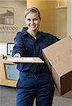 Young woman delivering box holding delivery receipt form.  Vertically framed shot.