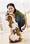 Woman filming dog with video camera. Vertically framed shot.