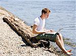 Man using laptop near stream