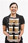 Businesswoman carrying stack of coffee cups