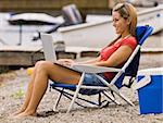 Woman using laptop on beach