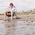 Man using laptop at beach