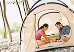 Couple playing boardgame in tent