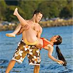 Boyfriend lifting girlfriend on beach