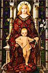 Stained glass window showing image of Madonna and Child. Vertical shot.