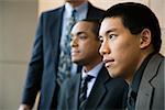 Asian businessman in the foreground with African-American businessman and a third businessman in the background. Horizontal format.