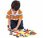 Adorable caucasian boy joining the blocks while playing on white background