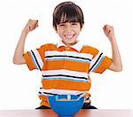 Young boy shows his strength by raising his arms on isolated white background