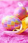 Bright coloured Easter eggs on pink