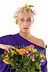 close up of pretty young blond girl in violet dress with flower and bouquet looking in camera with a surprise expression