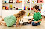 Kids on the floor teaching each other using the computers