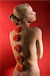 portrait of deaming cute girl with closed eyes on red background with some flowers on her back