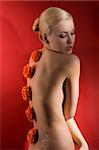 cute blond girl on red background with some flowers on her back like an ornament