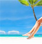 Woman on palm on caribbean beach