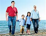 Portrait of happy family of four walking at beach