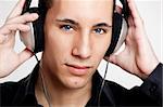 Portrait of a young man listening music with headphones