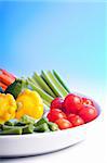 Selection of fresh veg on a spiral white plate.