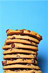 chocolate chip cookie stack on blue vertical upclose