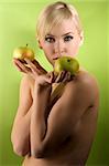 fashion and glamour shot of a nude young woman with apple on green background