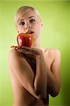sensual blond girl with a big red apple on her hand looking in camera