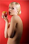 fashion shot of a glamour sensual girl with a red apple and nude body on red colored background