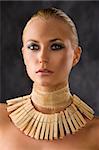portrait closeup of attractive blond woman like an amazon with a necklace made of wood peg