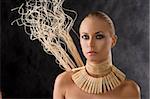 portrait on dark smoked background of beauty blond woman with necklace like an amazon