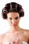 beauty portrait of a young brunette woman with hair curlers in her hair