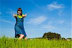 Portrait of a beautiful woman on a green meadow with thumbs up