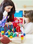 2-3 years girl playing with marionette in kindergarten. Vertical shape